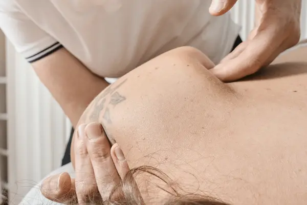 Le mani lavorano la parte alta della schiena